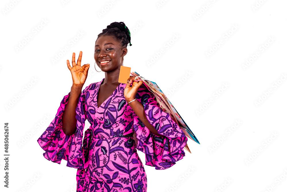 young businesswoman showing okay gesture holding credit card and shopping bags. young businesswoman showing okay gesture holding credit card and shopping bags.