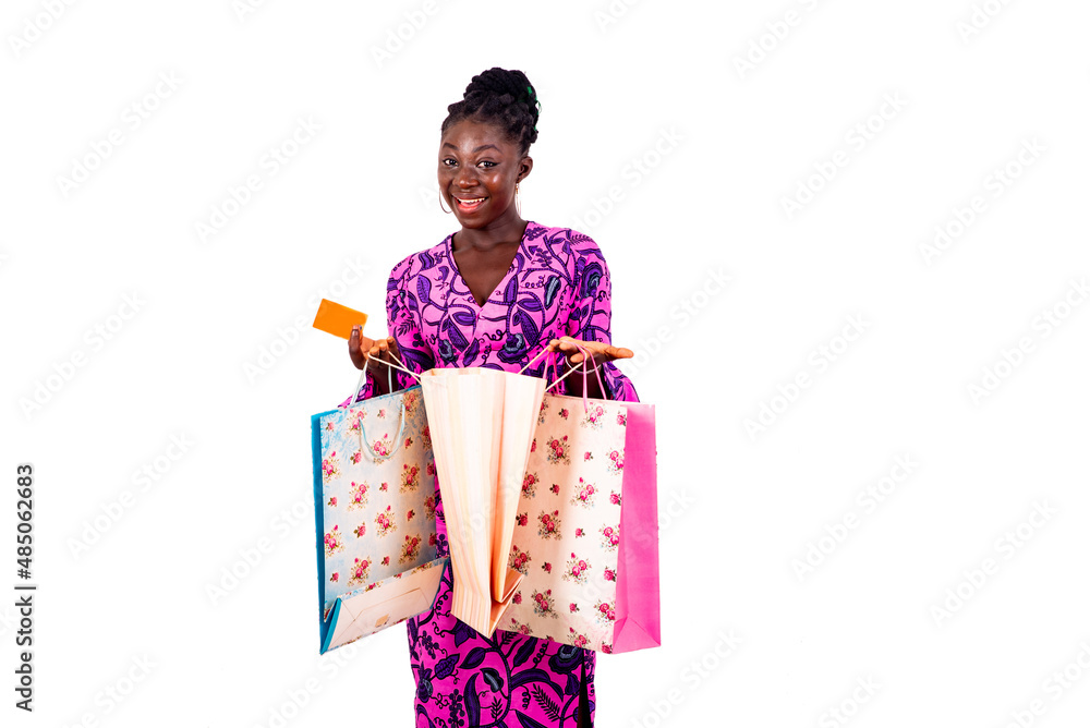 young businesswoman holding a credit card and shopping bags smiling. young businesswoman holding a credit card and shopping bags smiling.