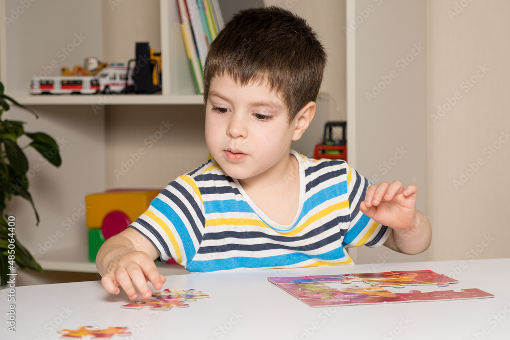 A preschooler plays puzzles, puts together a picture A preschooler plays puzzles, puts together a picture