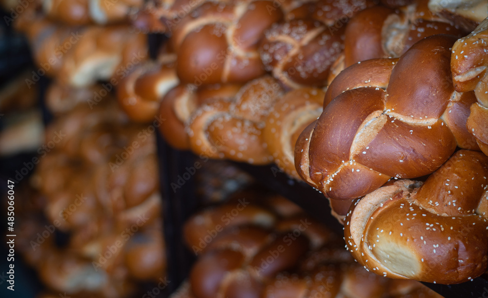 Fresh crispy delicious bread in form of braid lies on open stall of market. Bread is very famous product in different countries. Since ancient times people have learned to bake bread. Close-up. Fresh crispy delicious bread in form of braid lies on open stall of market. Bread is very famous product in different countries. Since ancient times people have learned to bake bread. Close-up.