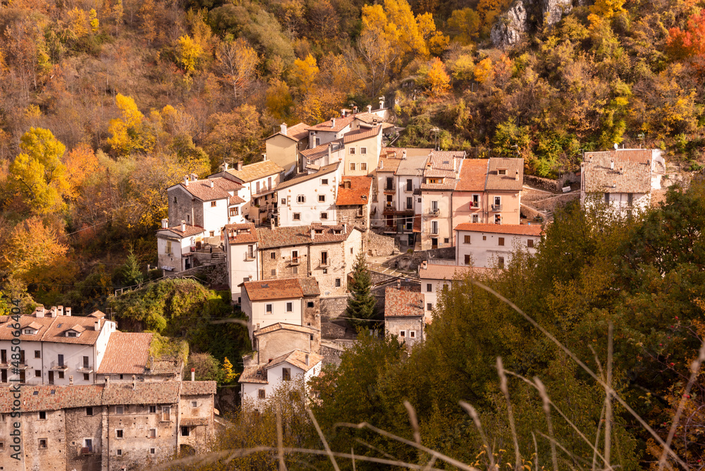 Small village in autumn lanscape with colorful trees in Italy