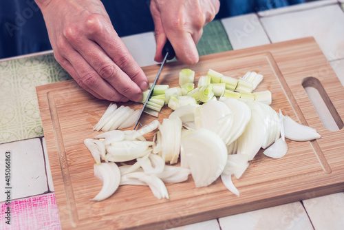 Person slicing a onion on a cutting board