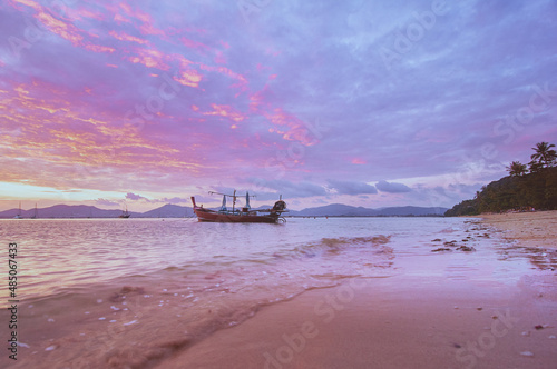Travel in Thailand.  Colorful landscape with sea beach, traditional longtail boat over beautiful sunset background. © luengo_ua