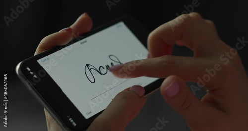 Digital signature on mobile screen by finger. Woman hand. Close-up photo