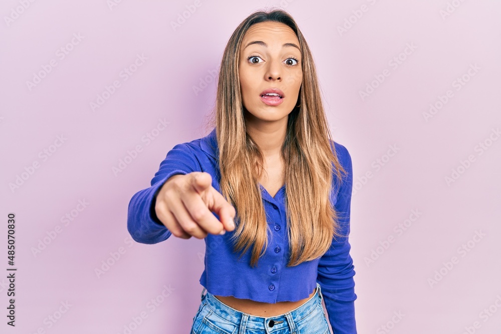 Beautiful hispanic woman wearing casual blue shirt pointing displeased and frustrated to the camera, angry and furious with you Beautiful hispanic woman wearing casual blue shirt pointing displeased and frustrated to the camera, angry and furious with you