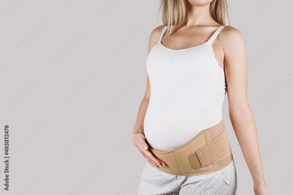 Pregnant woman belly in prenatal pregnancy maternity belt. Orthopedic abdominal support waist, back, abdomen band. Belly brace or band for pregnancy. Horizontal web banner. Torso of pregnant model Pregnant woman belly in prenatal pregnancy maternity belt. Orthopedic abdominal support waist, back, abdomen band. Belly brace or band for pregnancy. Horizontal web banner. Torso of pregnant model