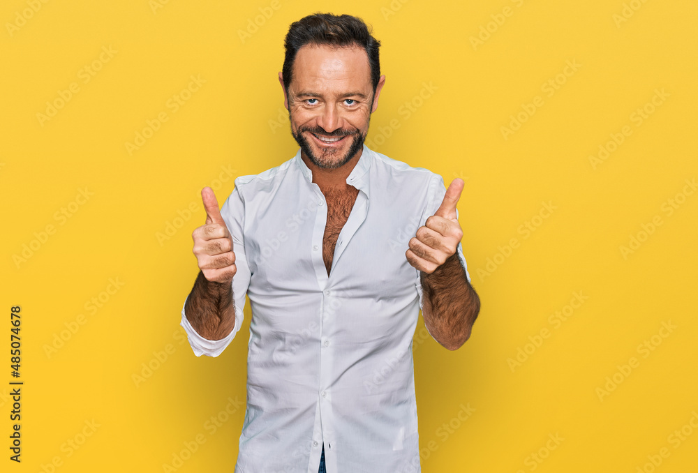 Middle age man wearing casual clothes success sign doing positive gesture with hand, thumbs up smiling and happy. cheerful expression and winner gesture. Middle age man wearing casual clothes success sign doing positive gesture with hand, thumbs up smiling and happy. cheerful expression and winner gesture.