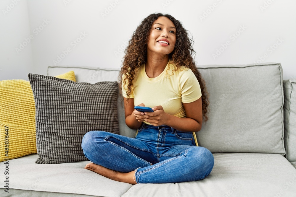 Young latin woman smiling confident using smartphone at home Young latin woman smiling confident using smartphone at home