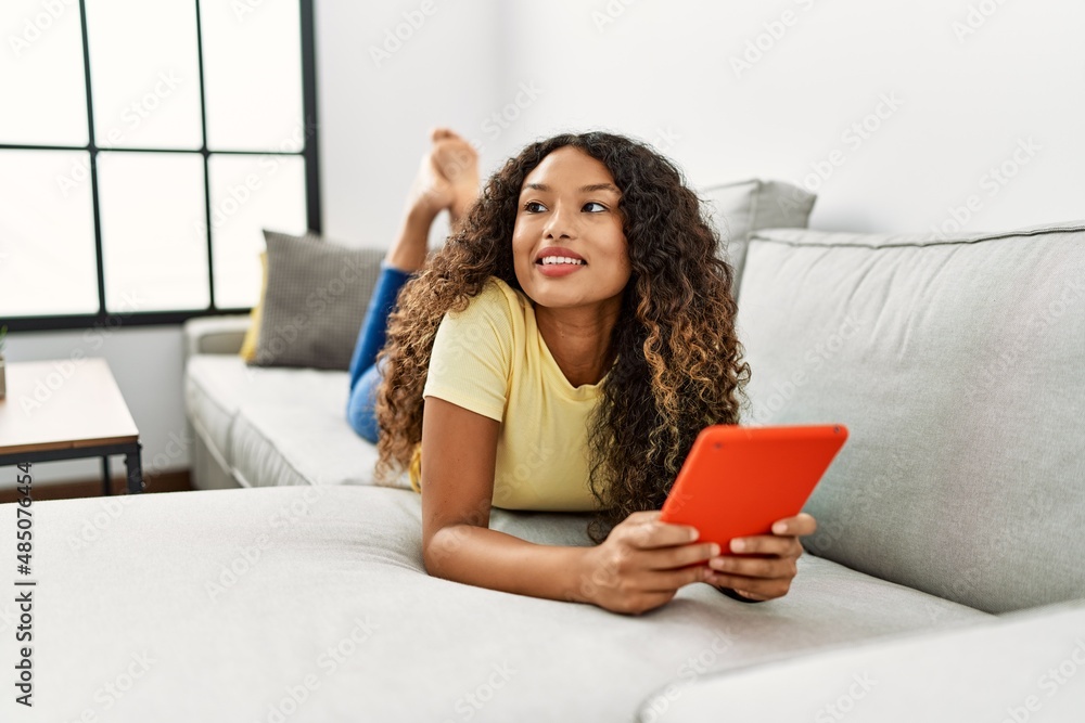 Young latin woman smiling confident using touchpad at home Young latin woman smiling confident using touchpad at home