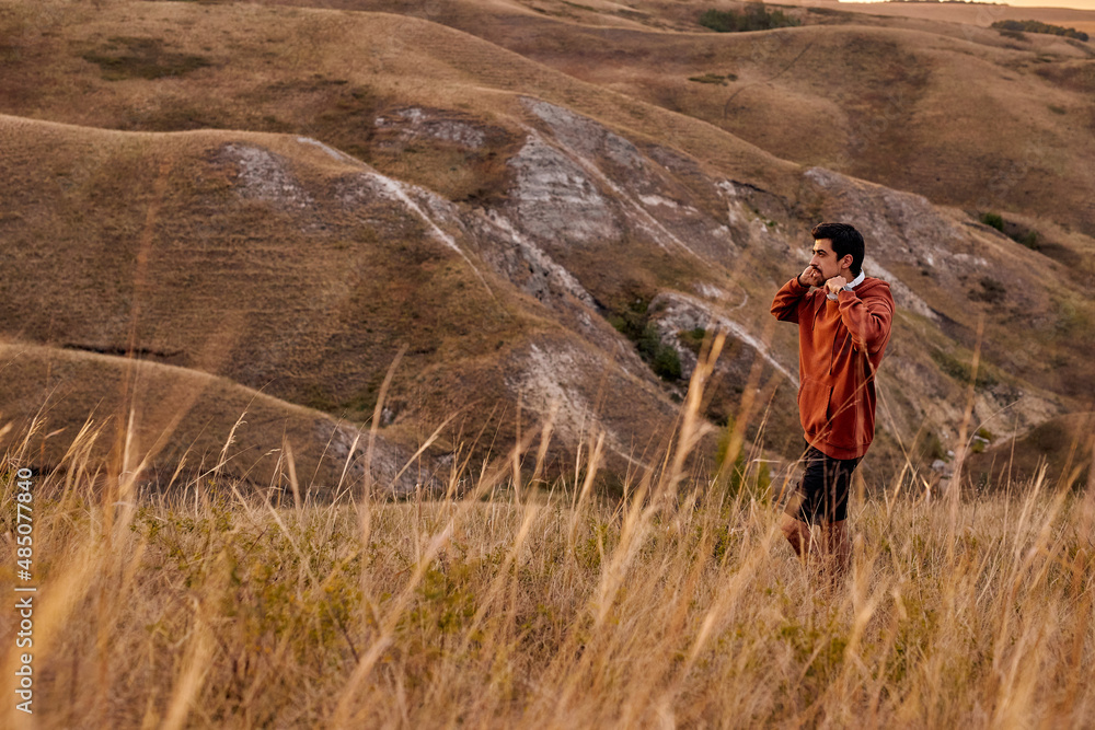 Naklejka premium Athlete man running sport. Runner have rest after jogging outdoors with beautiful landscape around. In nature. Male with headphones enjoy the view scene surrounding him, in contemplation