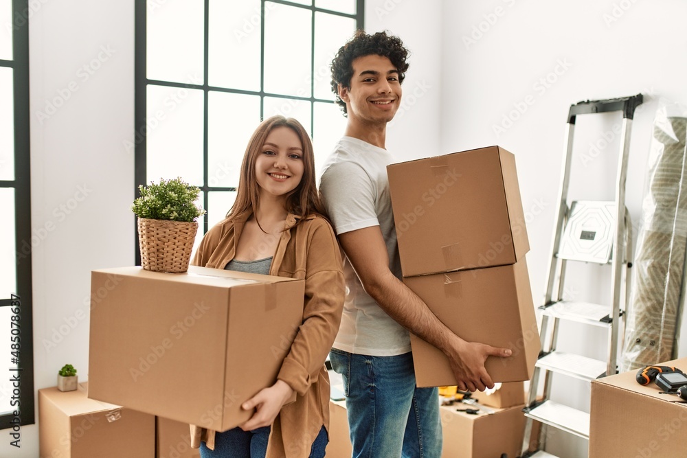 ¡Young couple smiling happy holding cardboard boxes at new home. ¡Young couple smiling happy holding cardboard boxes at new home.