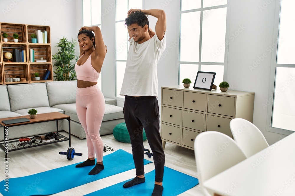 Obraz premium Young latin sporty couple smiling happy training at home.