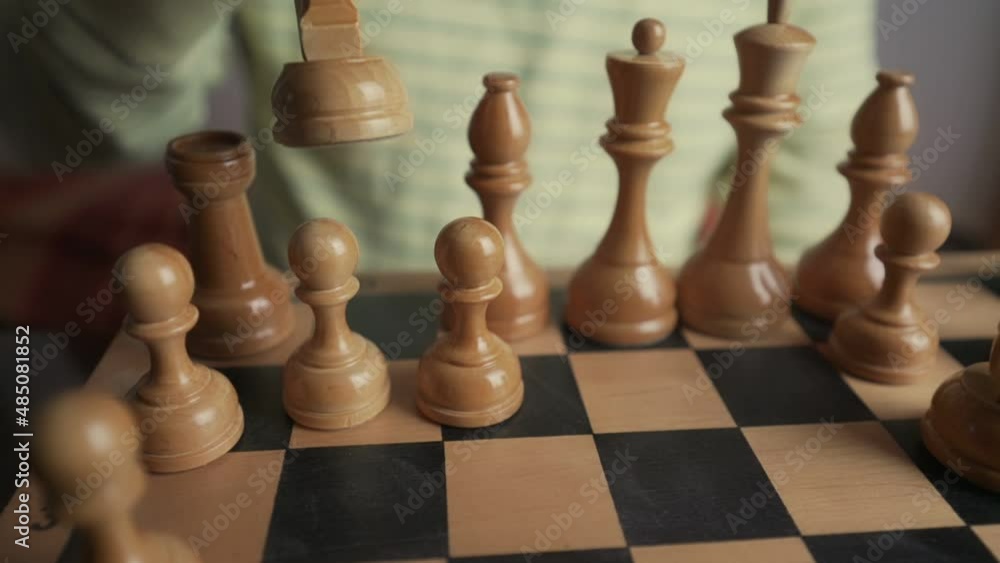 Experienced chess player makes knight move while playing chess game with white pieces Experienced chess player makes knight move while playing chess game with white pieces