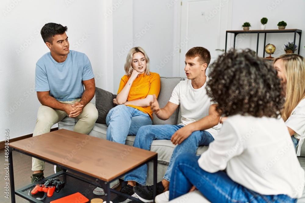 Group of young friends smiling happy sitting on the sofa at home. Group of young friends smiling happy sitting on the sofa at home.