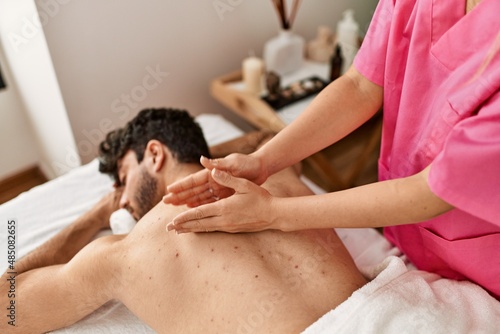 Man relaxed reciving back massage at beauty center.