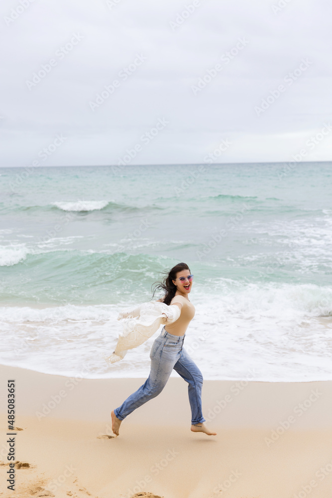 young beautiful girl having fun on the beach in Portugal against the backdrop of the Atlantic Ocean