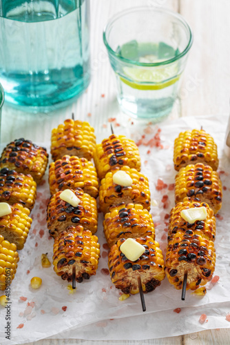 Homemade grilled corn cob served with citrus water.
