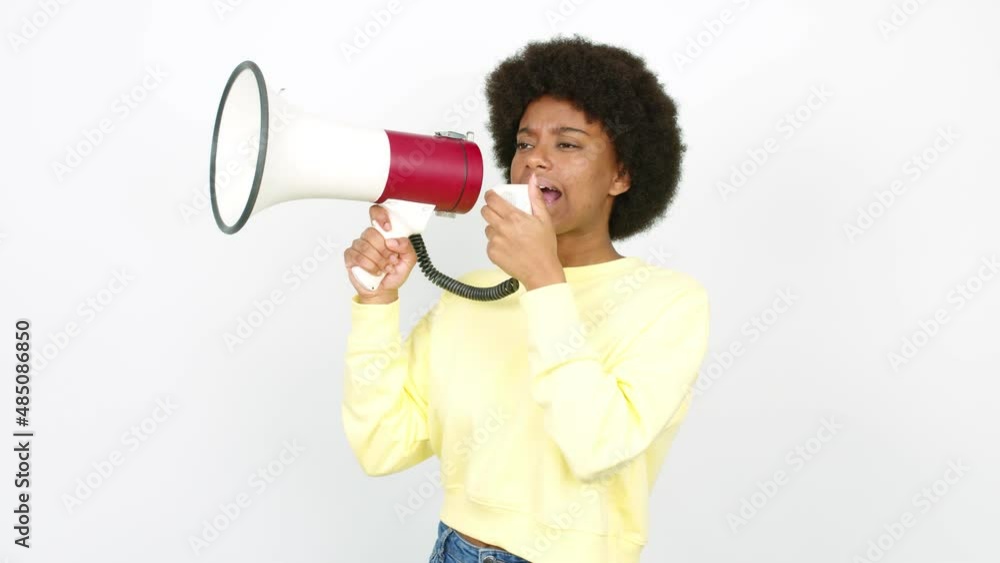 Young African American woman holding a megaphone and shouting over isolated background Young African American woman holding a megaphone and shouting over isolated background