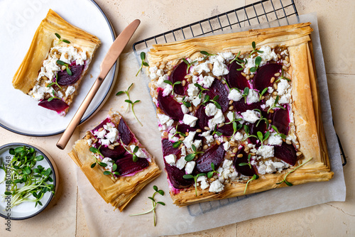 Beetroot and feta filo pizza. Beet Tart with feta, caramelized onion, pine nuts, sunflower micro greens and phyllo dough. Savoury vegetable vegetarian baking. photo
