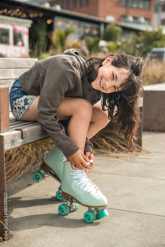 portrait of young child or teen girl roller skating outdoors, firness, wellbeing, active healthy lifestyle photo