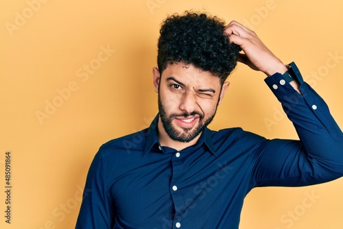 Fototapeta Young arab man with beard wearing casual shirt confuse and wonder about question