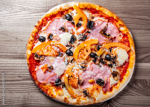 pizza with Mozzarella cheese, ham, mushrooms, olive. Italian pizza on wooden table background