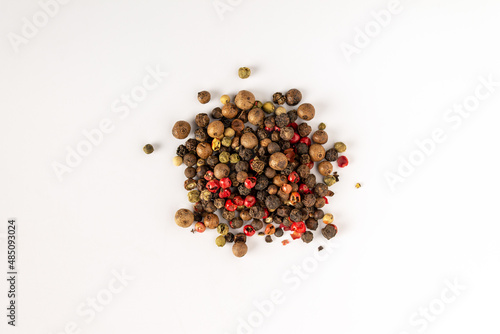 a bunch of colorful peppercorns on a white background, copy space