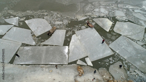 Workers use boats to push the ice over the water, North China