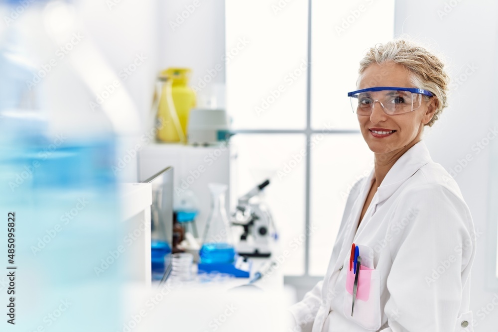 Middle age blonde woman wearing scientist uniform working at laboratory Middle age blonde woman wearing scientist uniform working at laboratory