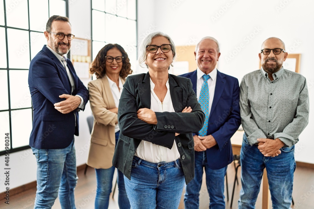 Fototapeta premium Group of middle age business workers smiling happy standing with arms crossed gesture at the office
