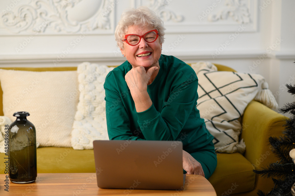 Happy old senior grey-haired woman grandmother to web cam video conference calling family Happy old senior grey-haired woman grandmother to web cam video conference calling family
