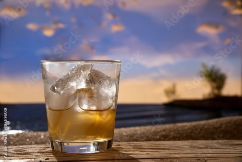 whiskey on the rock cocktail drink on wood table seaside