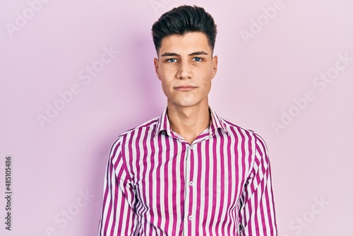 Young hispanic man wearing casual clothes relaxed with serious expression on face. simple and natural looking at the camera. © Krakenimages.com