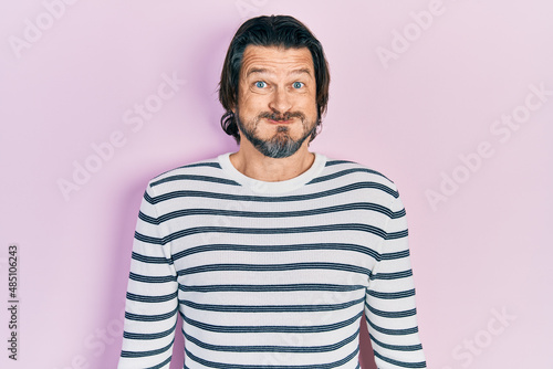 Middle age caucasian man wearing casual clothes puffing cheeks with funny face. mouth inflated with air, crazy expression.