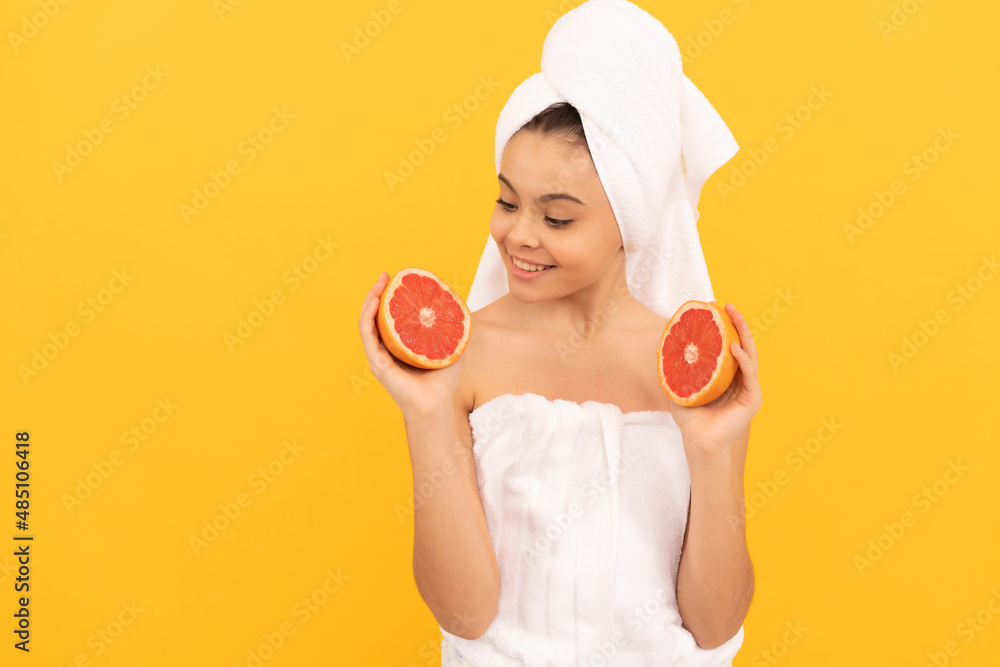 happy teen child in towel with grapefruit on yellow background happy teen child in towel with grapefruit on yellow background