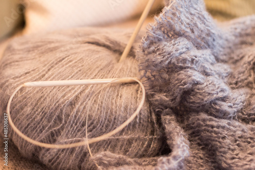 light grey woolen ball with knitting needles