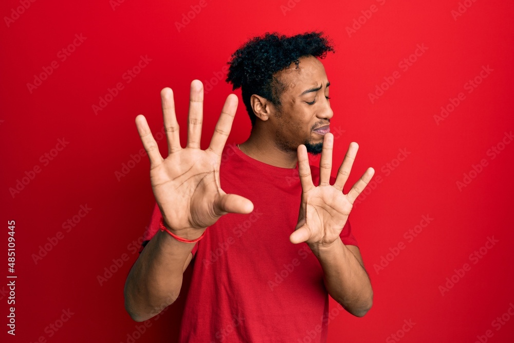 Φωτογραφία Young african american man with beard wearing casual red t shirt disgusted expression, displeased and fearful doing disgust face because aversion reaction