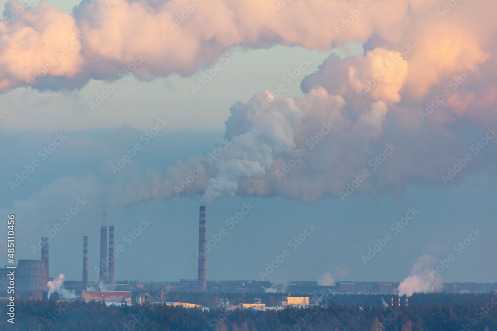 Smoke from the chimneys of a steel plant at sunset