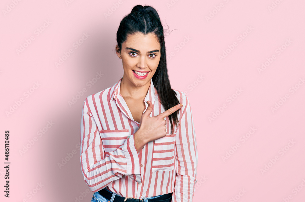Young hispanic woman wearing casual clothes smiling cheerful pointing with hand and finger up to the side Young hispanic woman wearing casual clothes smiling cheerful pointing with hand and finger up to the side