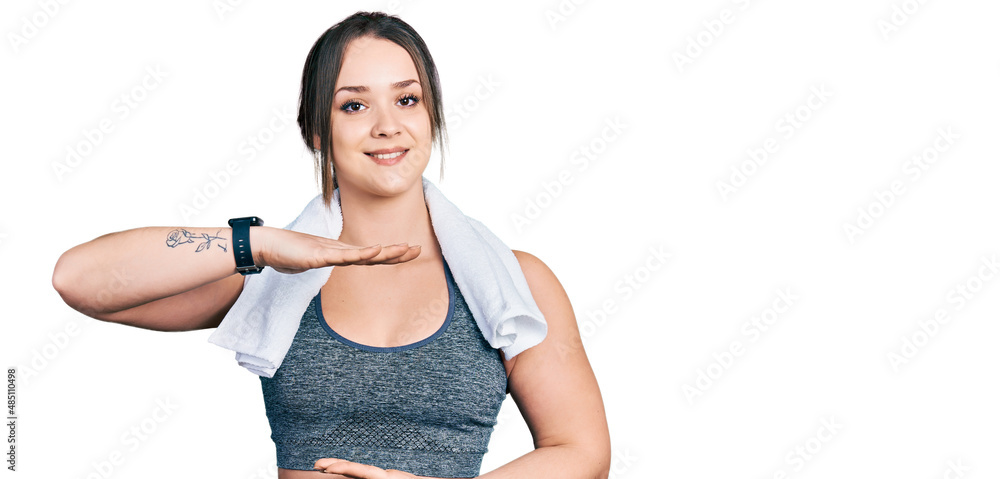 Young hispanic girl wearing sportswear and towel gesturing with hands showing big and large size sign, measure symbol. smiling looking at the camera. measuring concept. Young hispanic girl wearing sportswear and towel gesturing with hands showing big and large size sign, measure symbol. smiling looking at the camera. measuring concept.