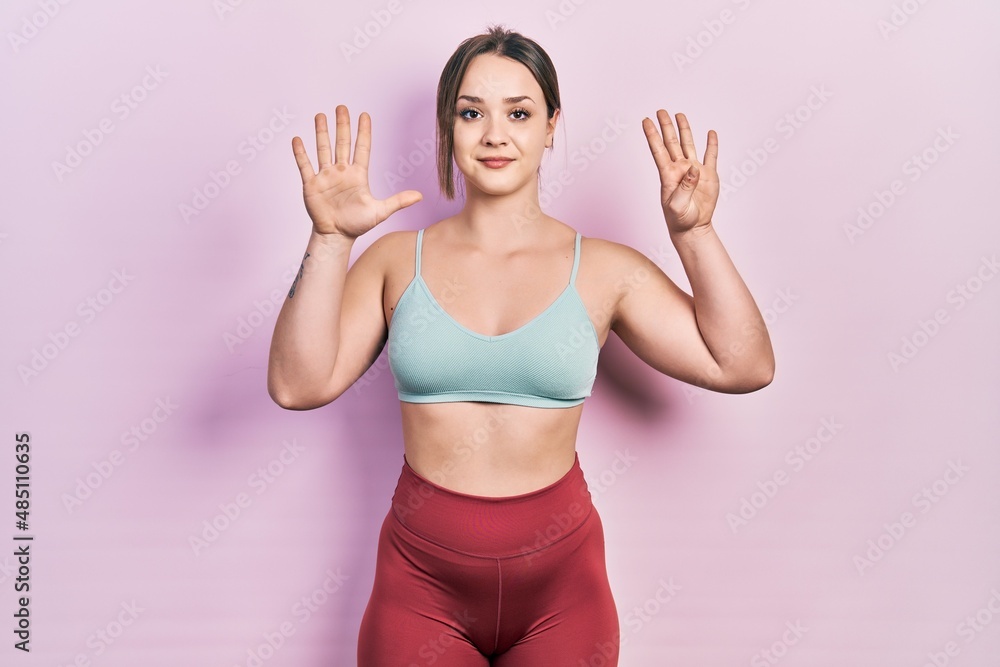 Young hispanic girl wearing sportswear showing and pointing up with fingers number nine while smiling confident and happy. Young hispanic girl wearing sportswear showing and pointing up with fingers number nine while smiling confident and happy.