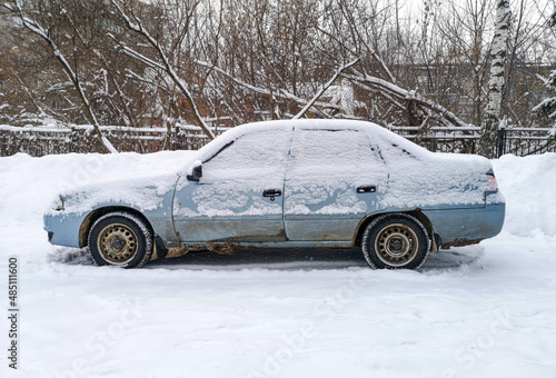 Car covered with snow near the road © schankz