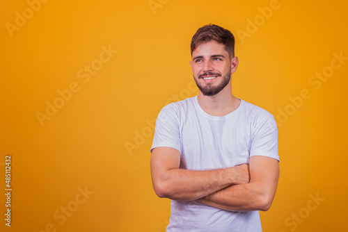 Young handsome boy smiling looking at camera with arms crossed.