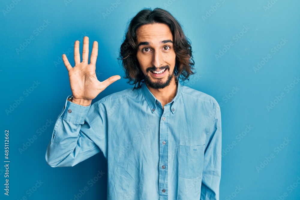 Young hispanic man wearing casual clothes showing and pointing up with fingers number five while smiling confident and happy. Young hispanic man wearing casual clothes showing and pointing up with fingers number five while smiling confident and happy.
