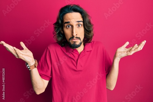 Billede på lærred Young hispanic man wearing casual clothes clueless and confused with open arms, no idea and doubtful face