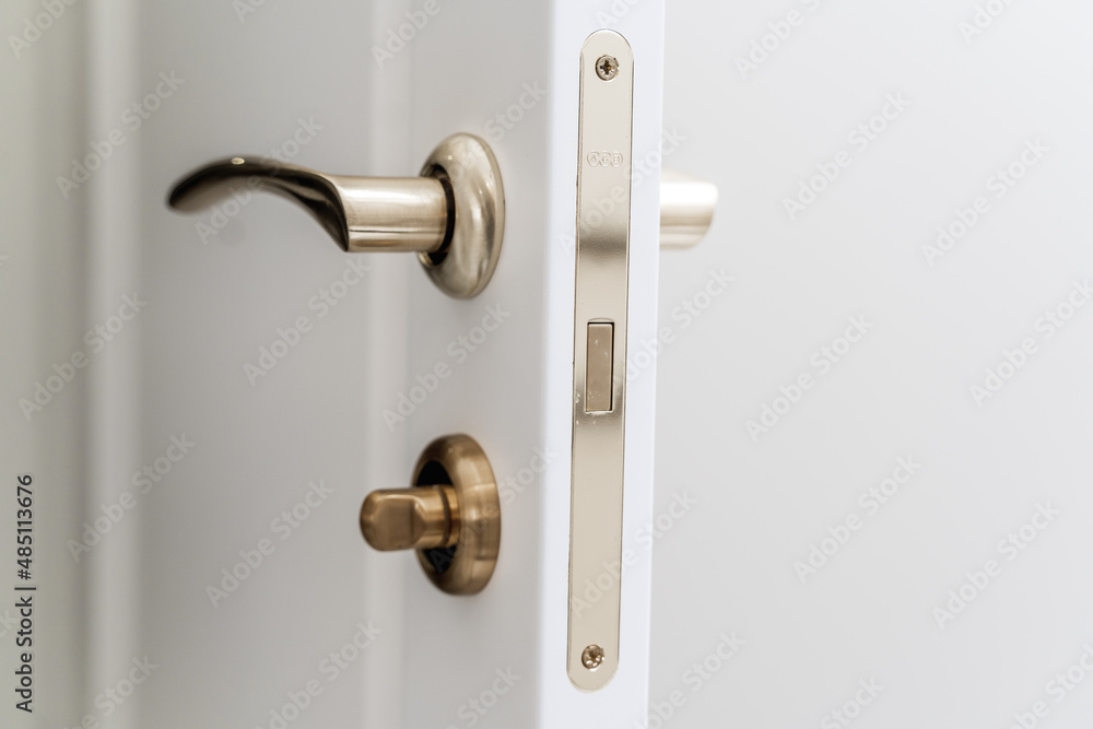 Stylish bronze door handle and lock on a white new interior door Stylish bronze door handle and lock on a white new interior door