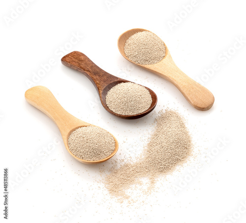Dry yeast in wooden scoop isolated on white background