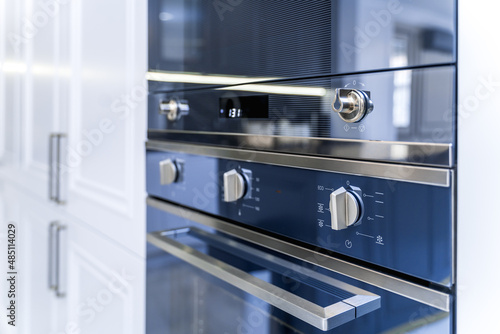 New stylish kitchen with black countertop and white appliances. Black and white cabinet doors