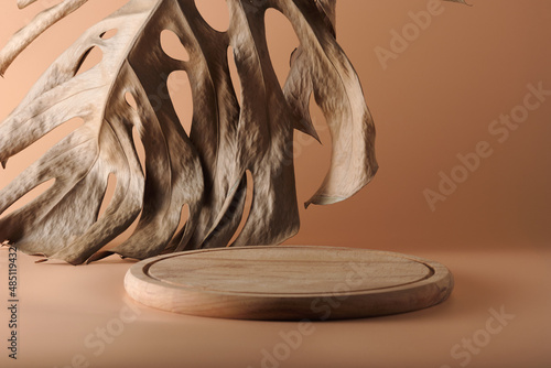 Wooden podium or tray. Mockup with meta for product. In the background is a dried monstera leaf. Monochrome image in beige tones. photo