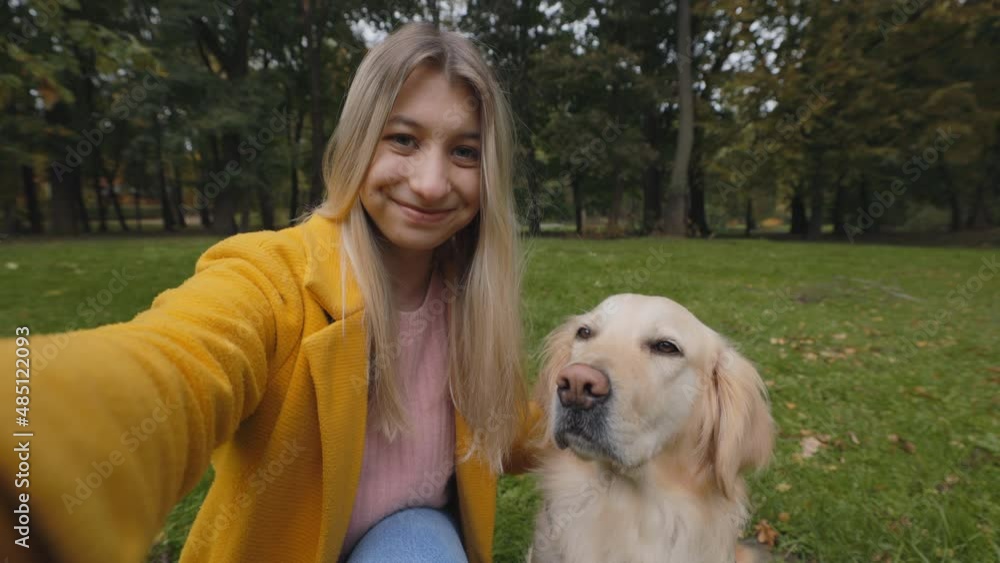 Happy woman filming video while petting her french retriever Happy woman filming video while petting her french retriever